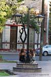 Mädchen sitzt unter einer Straßenlaterne, Plaza de Espana, Mendoza, Argentinien.