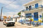 Terrasse und Besen-Verkäufer, Agia Kyriaki, Griechenland.