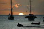Deshaies, Einstellung Halb Sonne zwischen Booten in der Silhouette, Guadeloupe.