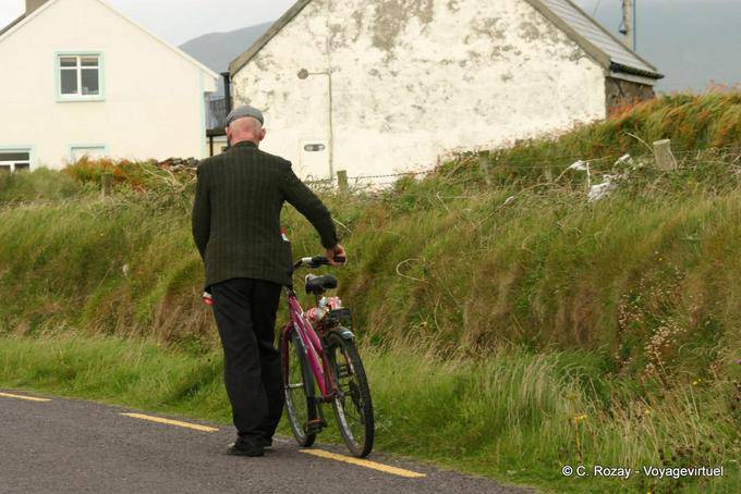 Die Weitergabe Kappe drückt seinem Fahrrad, Dingle - Irland