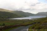 Lough und schmale Straße, Connemara, Irland.