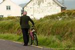 Die Weitergabe Kappe drückt seinem Fahrrad, Dingle, Irland.