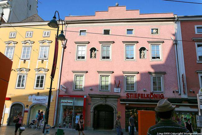 Landstraße, rosafarbene Fassade mit Statuen in Nischen, Linz - Österreich