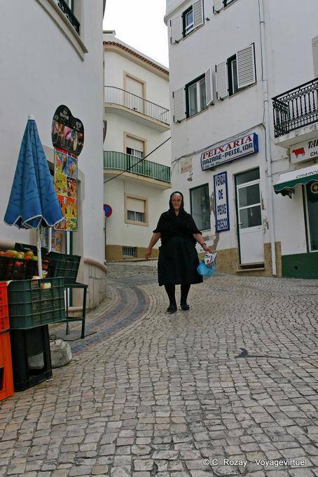 Die Frau in Schwarz in den Kopfsteinpflasterstraße, Nazaré - Portugal