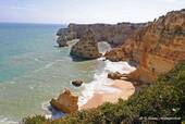 Cliff und rosa Sand von der Küste der Algarve, Portugal.