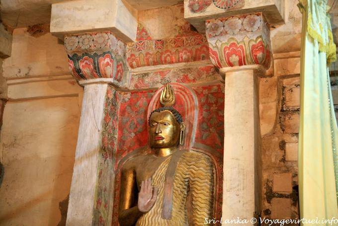 Stehender Buddha nachsichtig auf gemalten Hintergrund, Gadaladeniya Tempel in Kandy - Sri Lanka